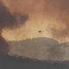 A fire-fighting helicopter approaches an out of control fire in the Bunyip State Park.